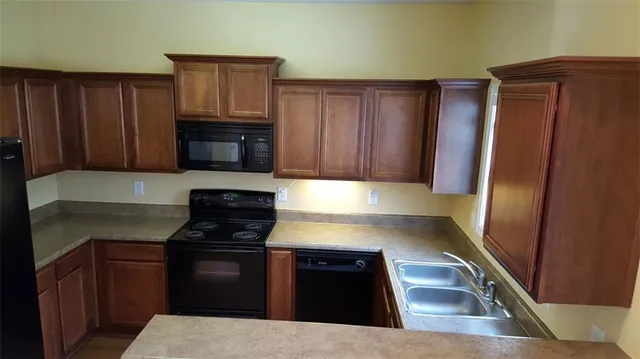 a kitchen with granite countertop stainless steel appliances and wooden cabinets