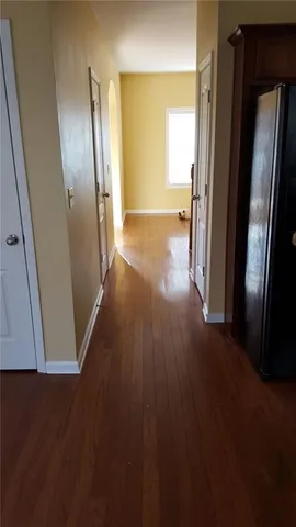 an empty room with wooden floor and a bathroom