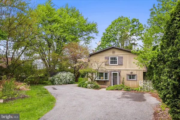 a front view of a house with yard and green space