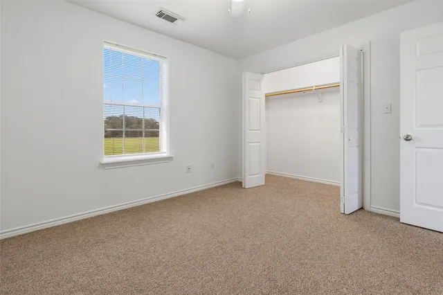 an empty room with windows and closet