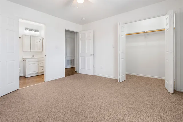 an empty room with closet and windows