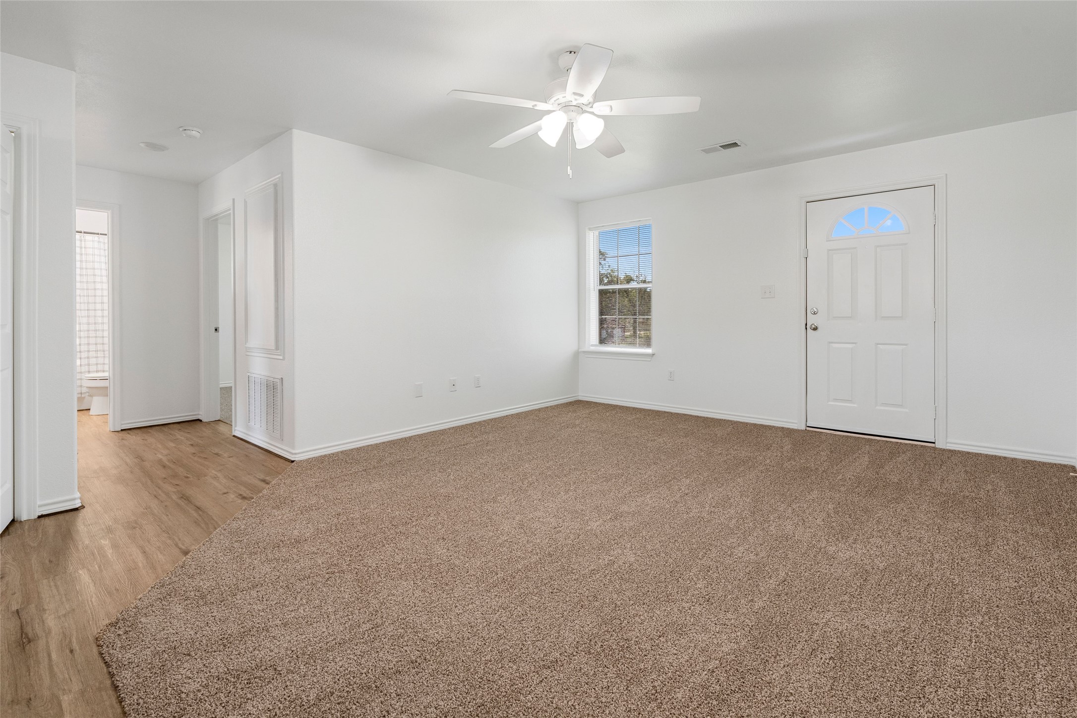 210 Brazos Street, Unit 202 Brazoria, TX 77422 - Photo 2 of 20 a view of a big room with windows and chandelier fan
