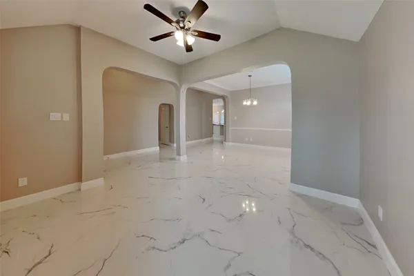 a view of a hallway with a chandelier fan and windows