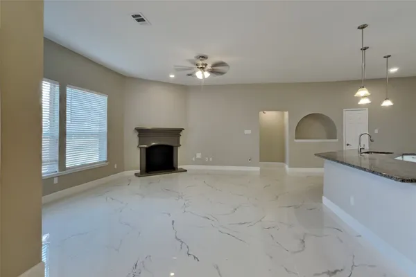 a view of an empty room with a fireplace and a window