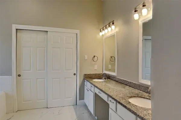 a bathroom with a granite countertop sink and a mirror