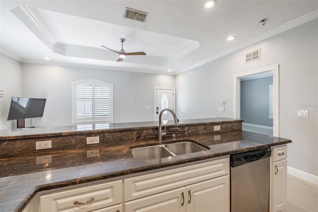 2323 West Cherry Street Tampa, FL 33607 - Photo 5 of 20 a kitchen with granite countertop a sink and white cabinets