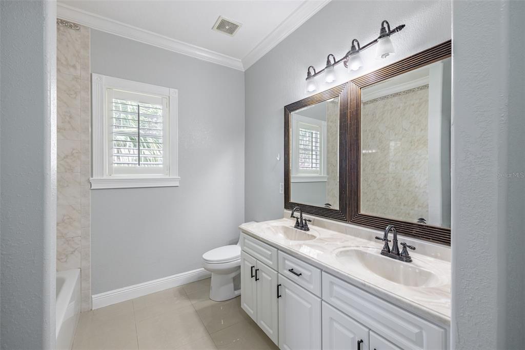 2323 West Cherry Street Tampa, FL 33607 - Photo 9 of 20 a bathroom with a double vanity sink a toilet and a mirror