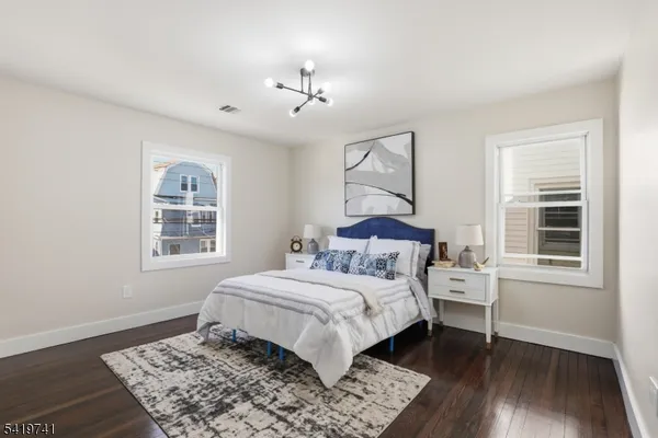 a bedroom with a large bed chandelier and a window