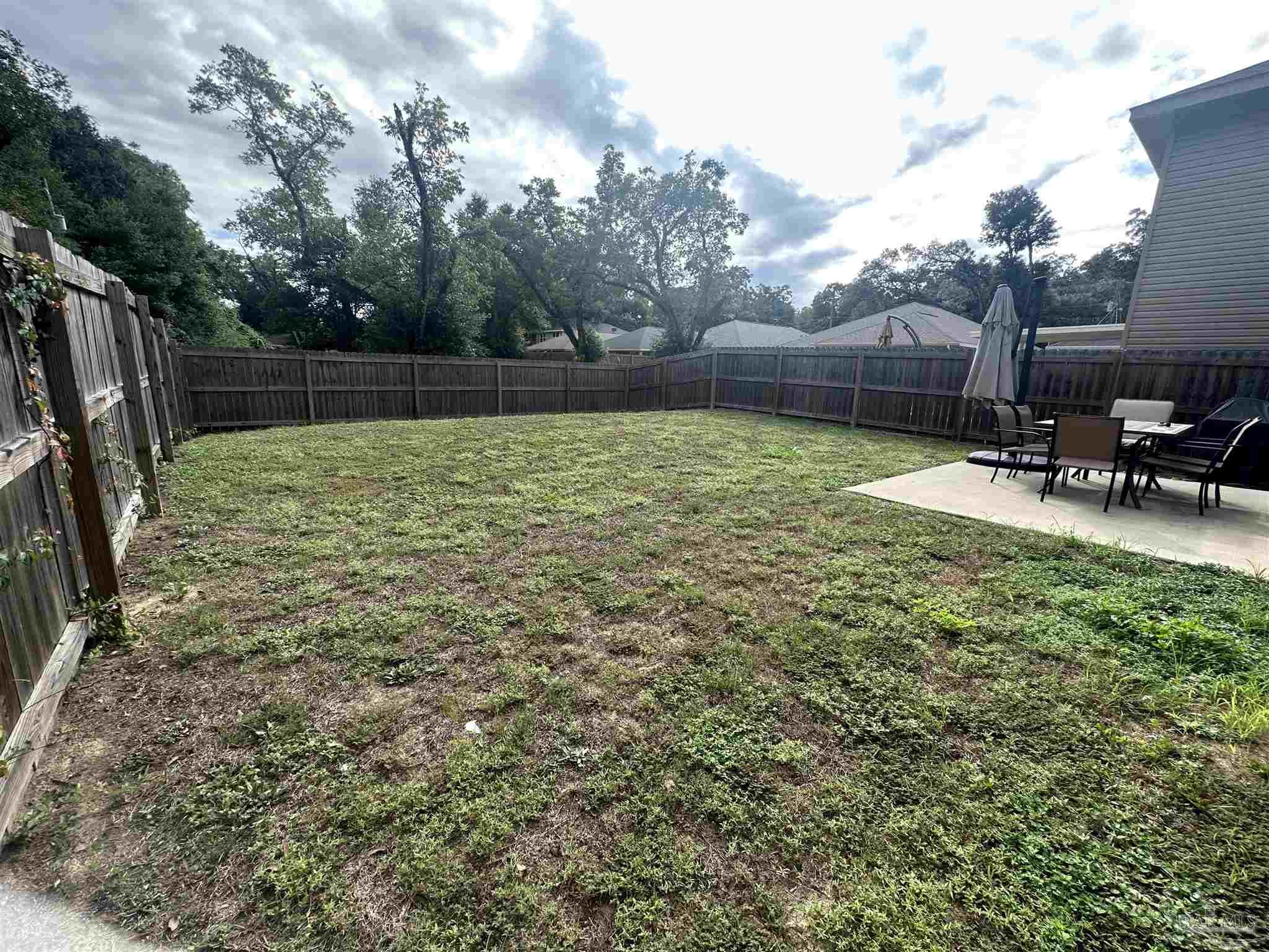 5217 Saufley Field Road Pensacola, FL 32526 - Photo 25 of 26 a view of a backyard with a table and chairs