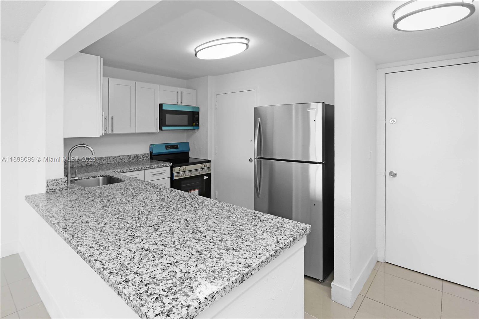 9001 Southwest 77th Avenue, Unit C803 Miami, FL 33156 - Photo 13 of 20 a kitchen with stainless steel appliances granite countertop a refrigerator and a sink
