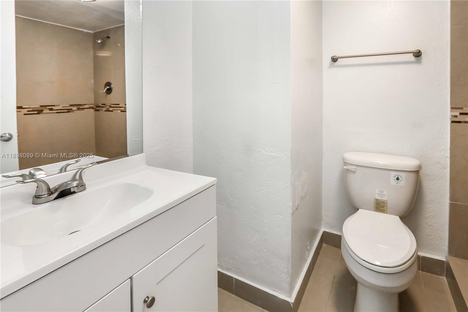 9001 Southwest 77th Avenue, Unit C803 Miami, FL 33156 - Photo 18 of 20 a bathroom with a sink a toilet and shower