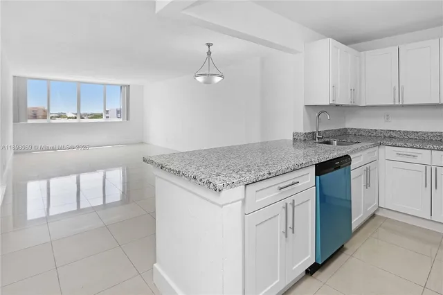 a kitchen with granite countertop white cabinets white appliances a sink and dishwasher