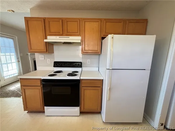 a white stove top oven sitting inside of a kitchen