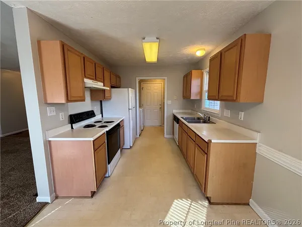 a kitchen with stainless steel appliances granite countertop a stove a sink a refrigerator and a microwave