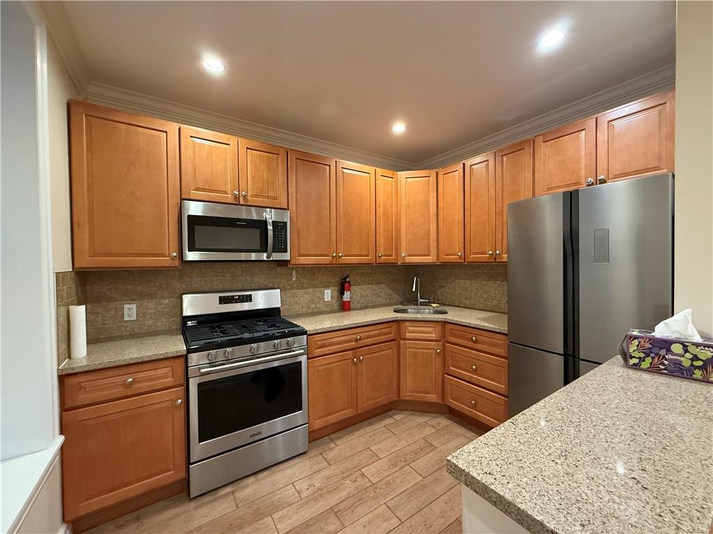 413 88th Street Brooklyn, NY 11209 - Photo 2 of 7 a kitchen with granite countertop a refrigerator stove and microwave