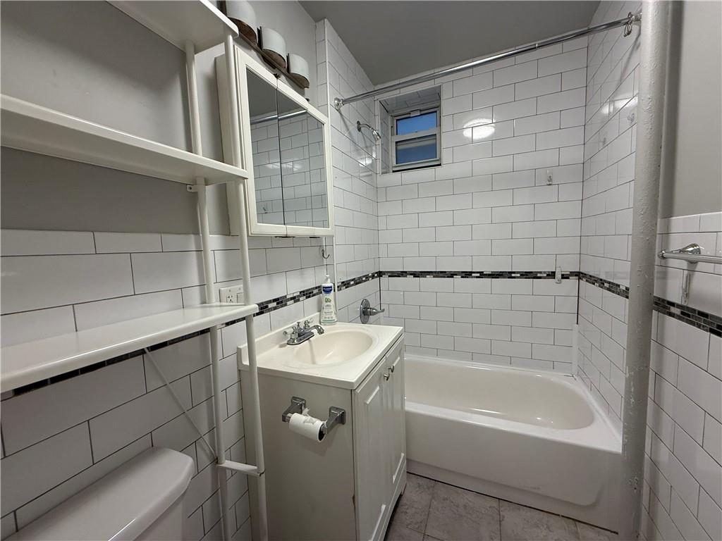 413 88th Street Brooklyn, NY 11209 - Photo 4 of 7 a bathroom with a bathtub and shower