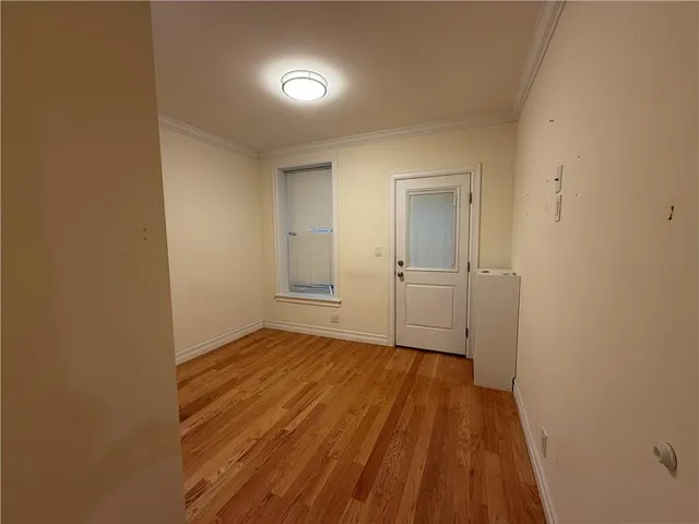 a view of a room with wooden floor and a bathroom