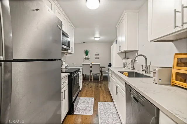 a kitchen with sink a refrigerator and cabinets