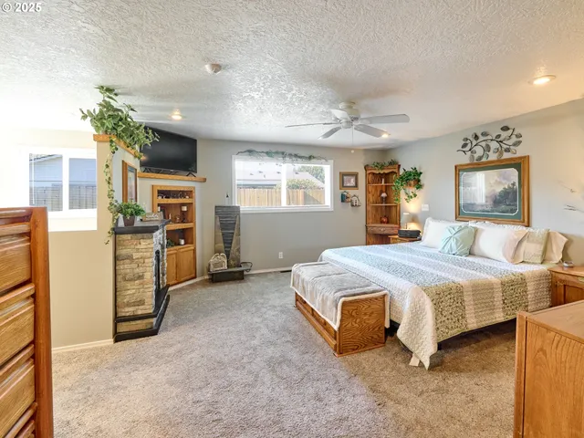 a spacious bedroom with a bed and a flat tv screen