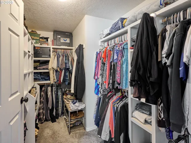 a view of walk in closet with clothes