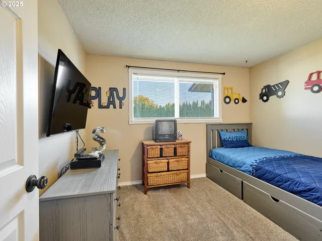 a bedroom with furniture and a flat screen tv