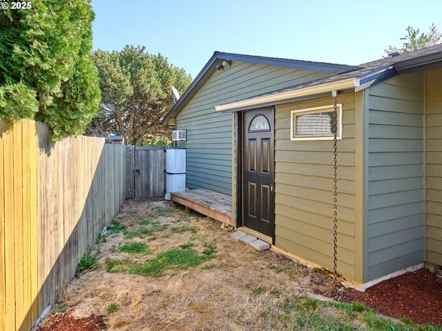 a view of small house with a small yard and wooden fence