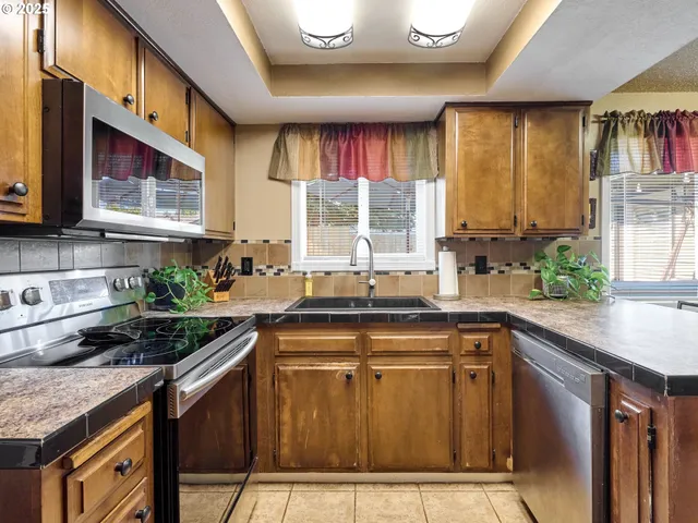 a kitchen with stainless steel appliances granite countertop a sink a stove and a microwave