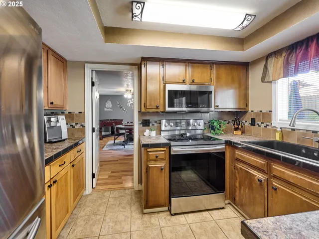 a kitchen with stainless steel appliances granite countertop a stove top oven a sink dishwasher and cabinets