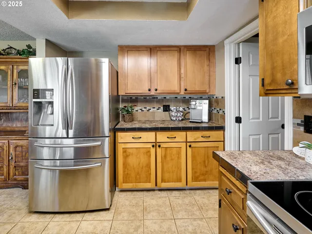 a kitchen with stainless steel appliances granite countertop a refrigerator and a stove