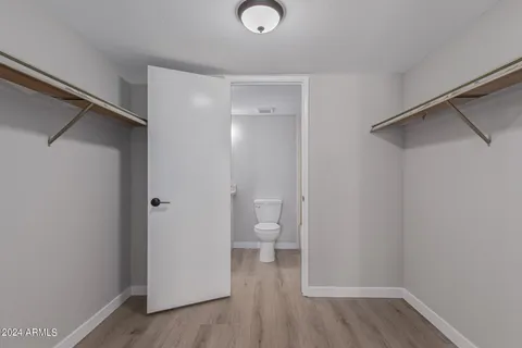 a view of bathroom with a toilet a sink and wooden floor