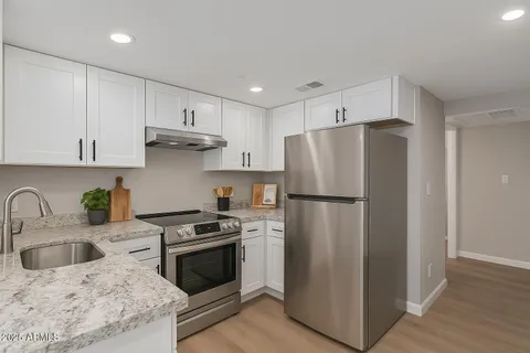 a kitchen with a refrigerator sink and cabinets