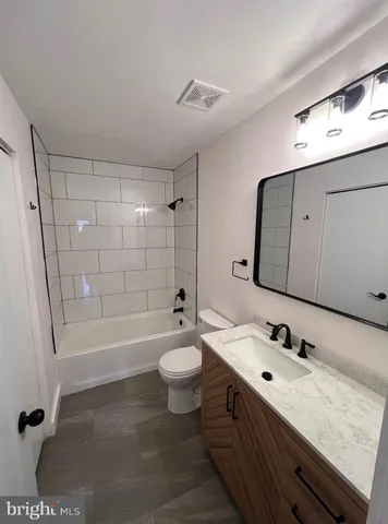 a bathroom with a double vanity sink toilet mirror and shower
