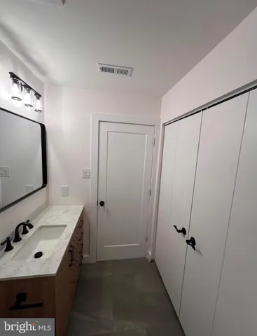 a bathroom with a sink vanity and mirror