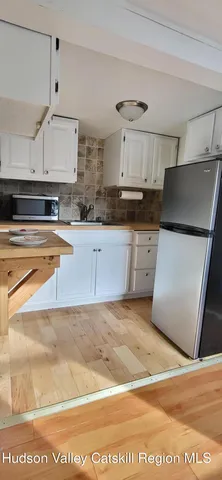 a kitchen with stainless steel appliances a stove a sink and white cabinets