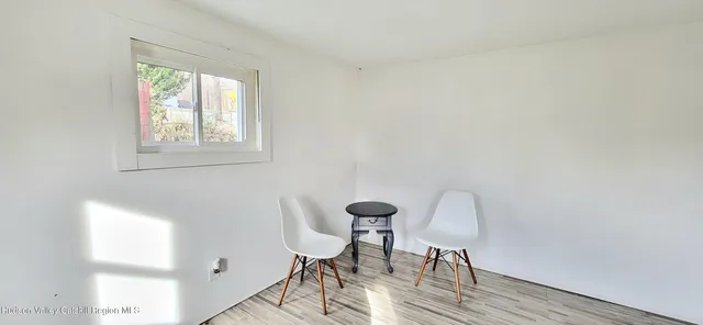 a view of a workspace with furniture and a window