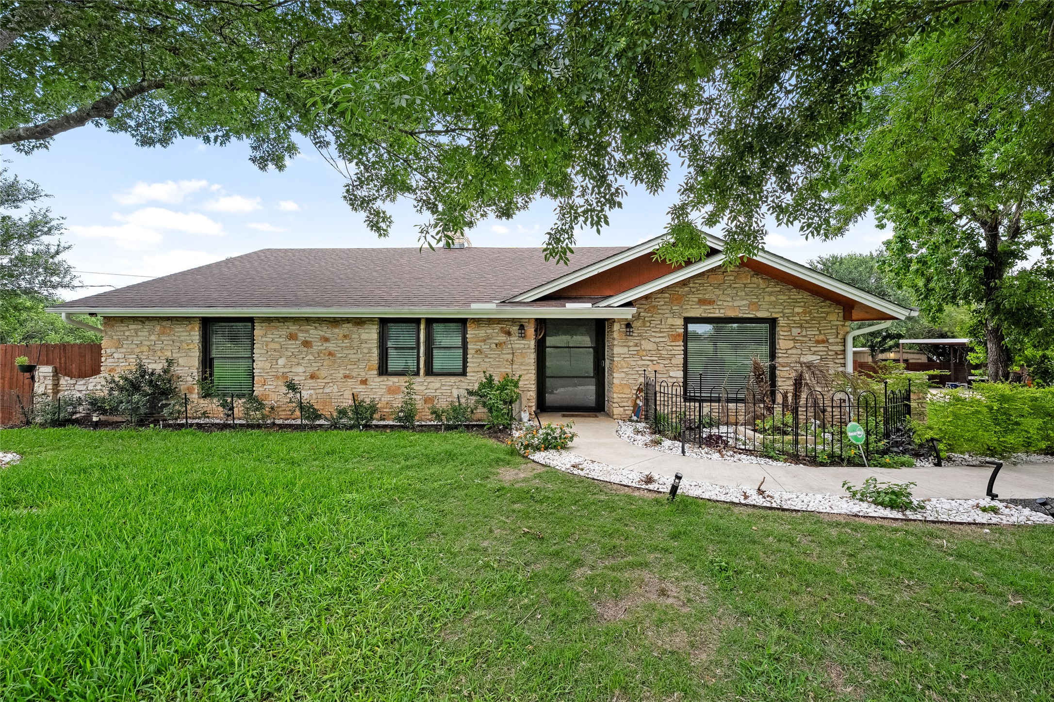 301 Oak Ridge Road Georgetown, TX 78628 - Photo 1 of 34 Stone facade home featuring a prominent front entrance, dark trim windows, and a brown shingle roof