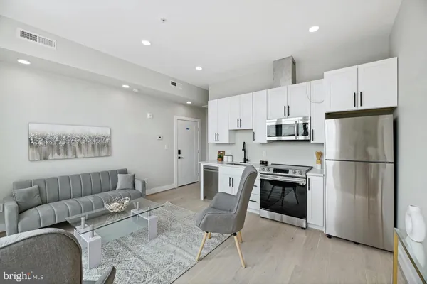 a kitchen with stainless steel appliances kitchen island granite countertop a refrigerator and a stove top oven