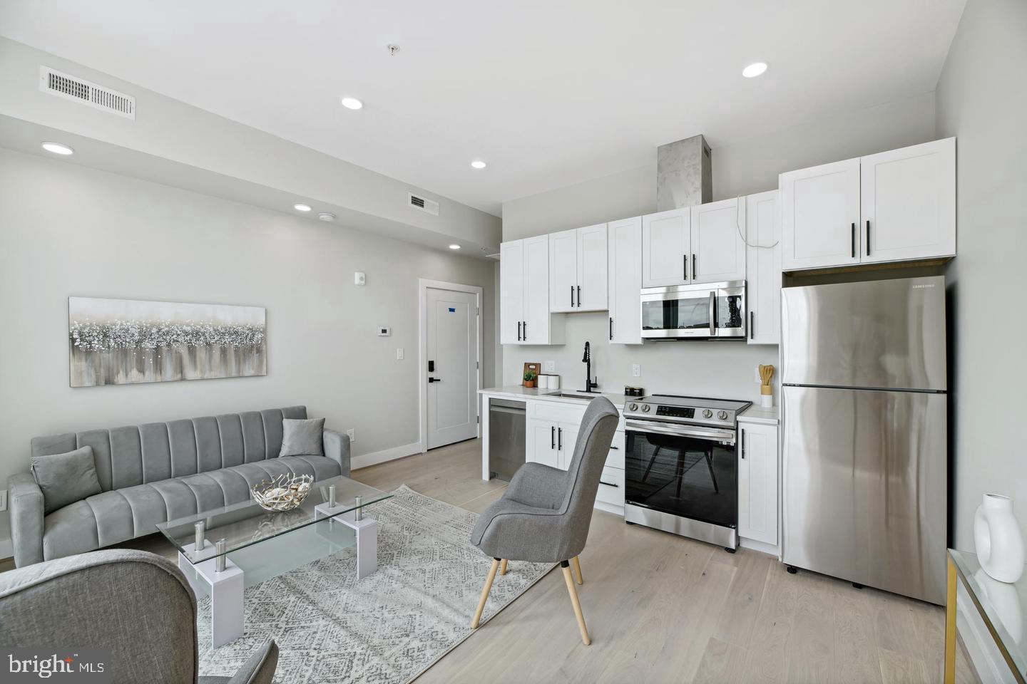 a kitchen with stainless steel appliances kitchen island granite countertop a refrigerator and a stove top oven