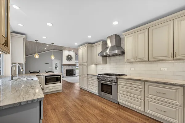 a kitchen with stainless steel appliances granite countertop a stove and cabinets