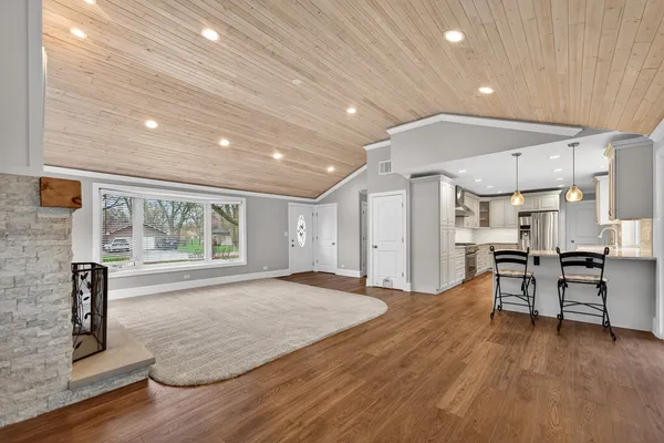 a view of empty room with wooden floor and furniture