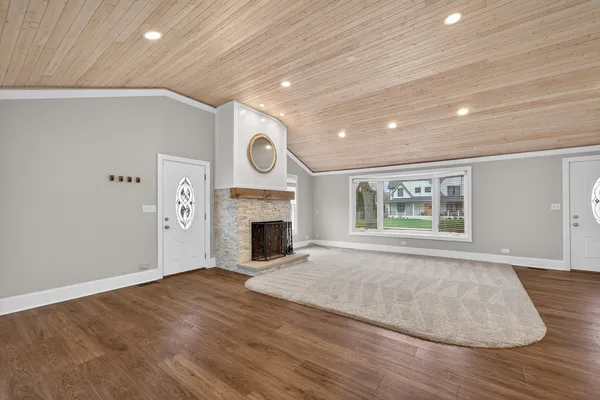 a view of empty room with wooden floor and fireplace