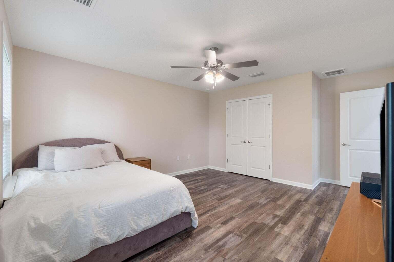 952 Mapoles Street Crestview, FL 32536 - Photo 26 of 32 a bedroom with a large bed and a chandelier