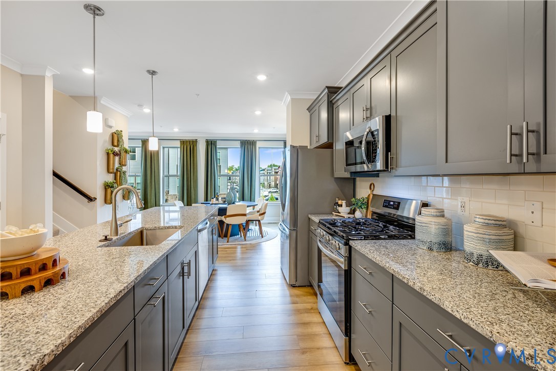 6103 Primrose Path Road Richmond, VA 23225 - Photo 5 of 23 a kitchen with granite countertop lots of counter top space a sink stainless steel appliances and cabinets
