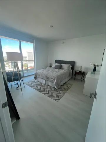 a spacious bedroom with a bed and large mirror