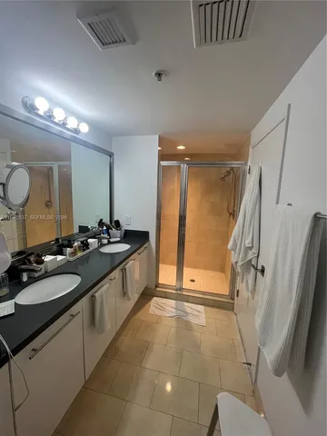a large bathroom with a sink a toilet a mirror and shower