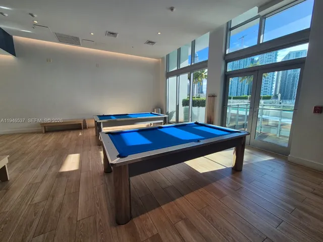 a room with pool table and windows