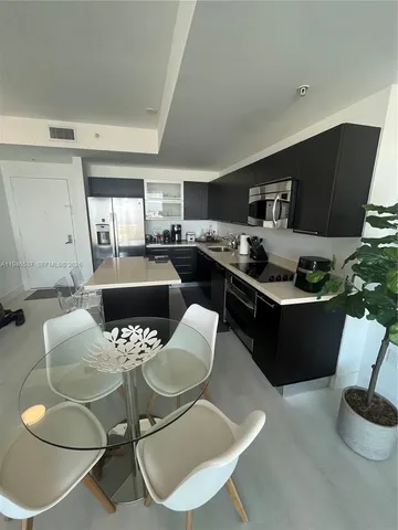 a kitchen with stainless steel appliances kitchen island granite countertop a sink and a stove