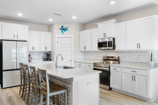 a kitchen with white cabinets stainless steel appliances and sink