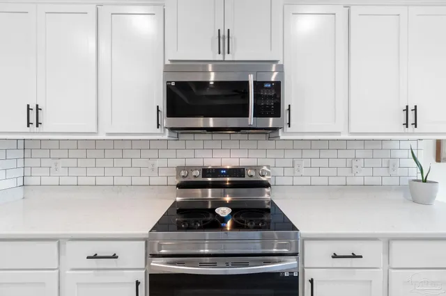 a kitchen with granite countertop a sink stainless steel appliances and cabinets