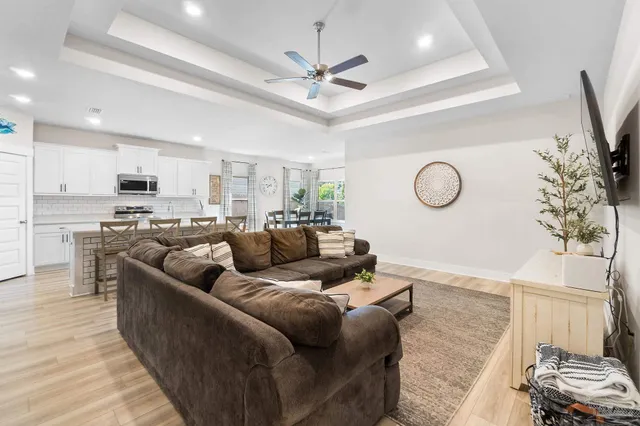 a living room with furniture kitchen and a chandelier